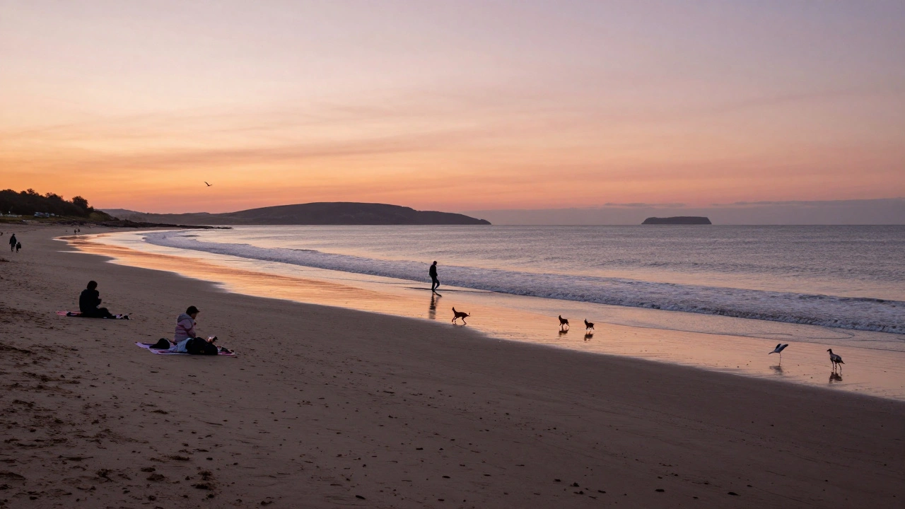 Sunset over Troon Beach with surfer and Isle of Arran on horizon.