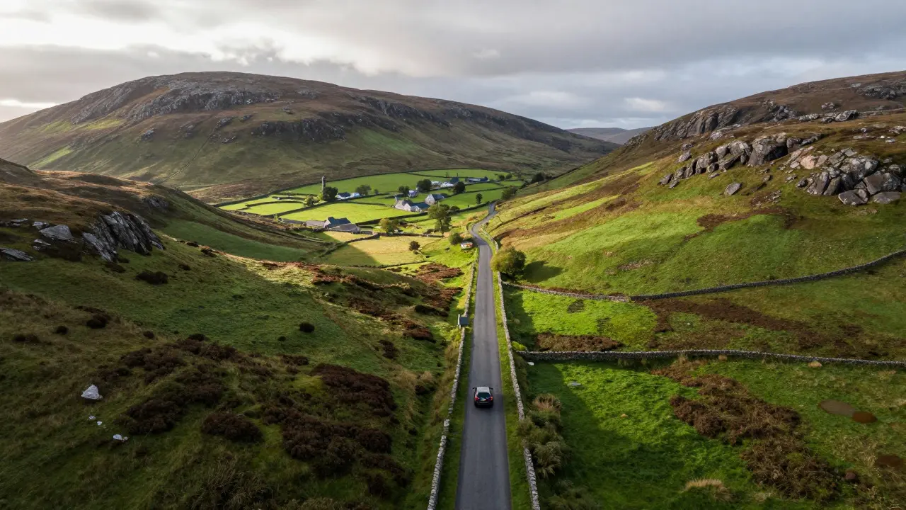 Rental car driving on a rural road through the green hills of Islay
